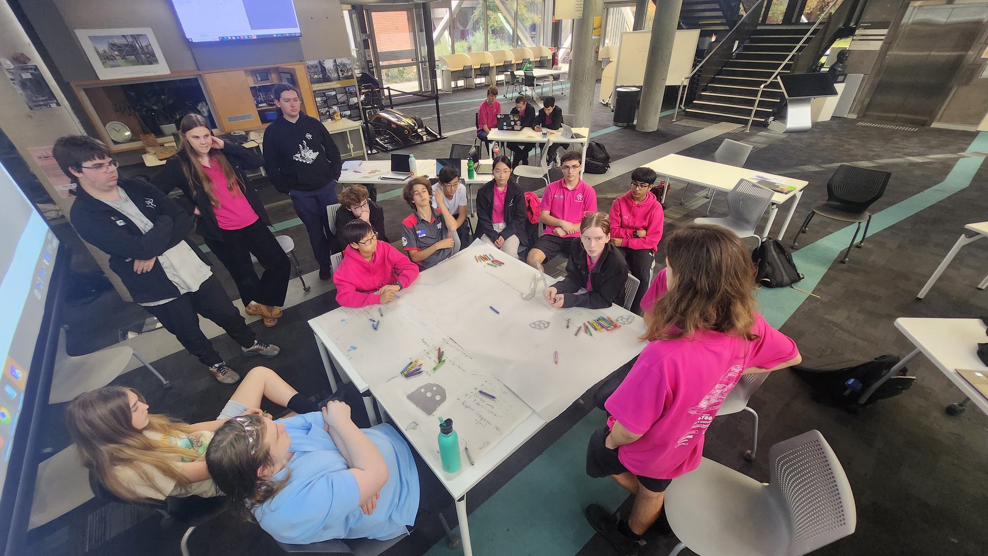Team 4788 gathers around a table to discuss robot