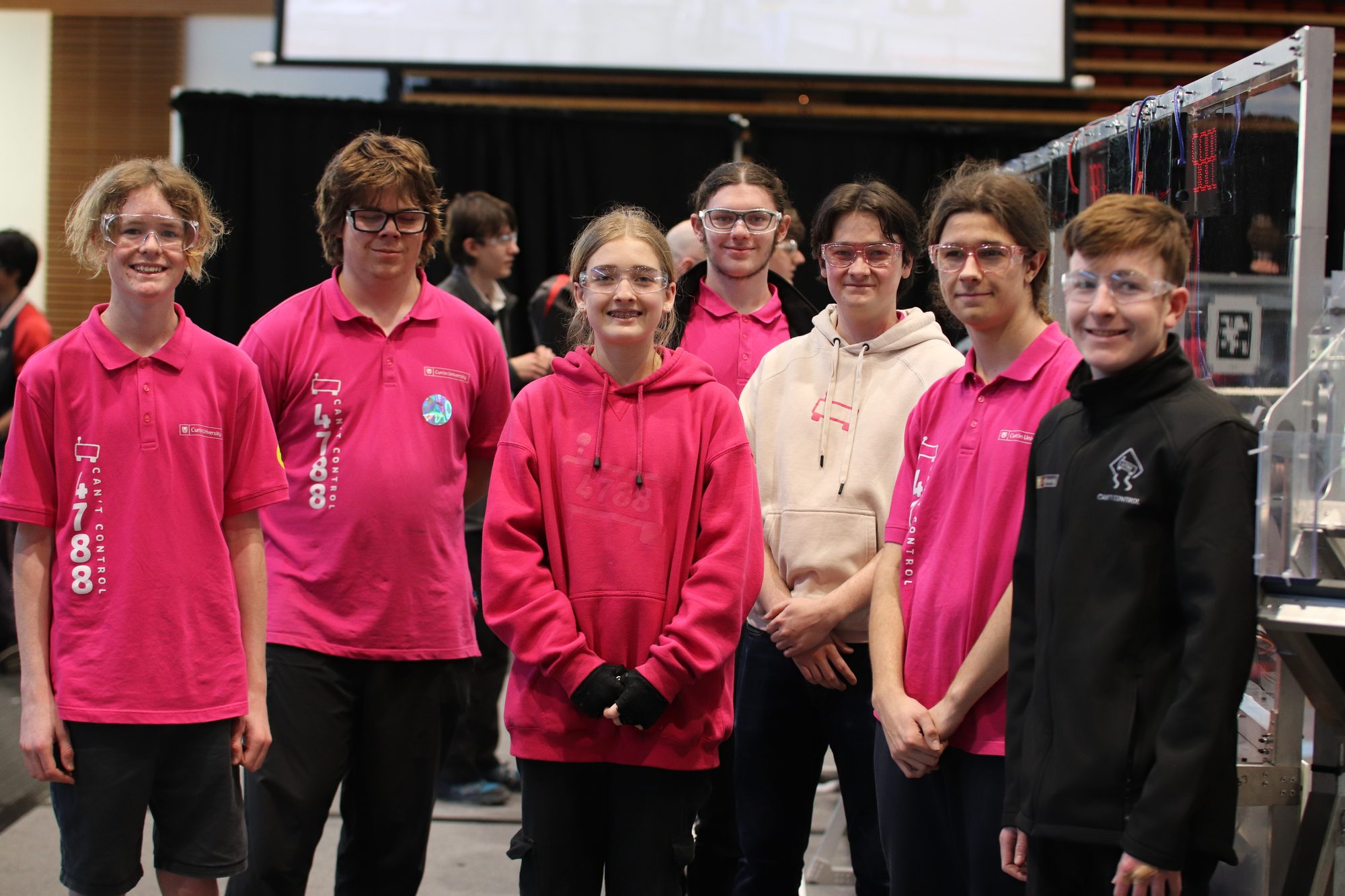 Team members in pink shirts at a competition