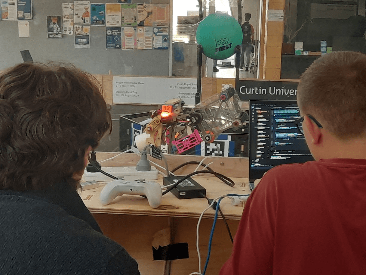 Two students programming the robot at a laptop